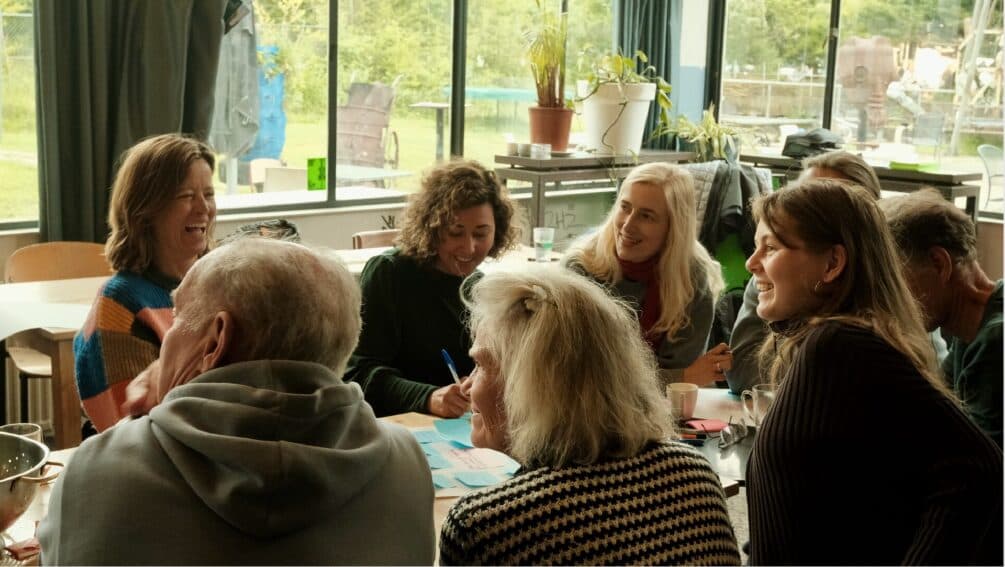 Een groep mensen in gesprek aan een tafel