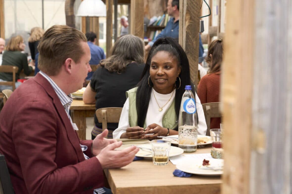 Gasten in gesprek aan tafel tijdens het dialoogdiner